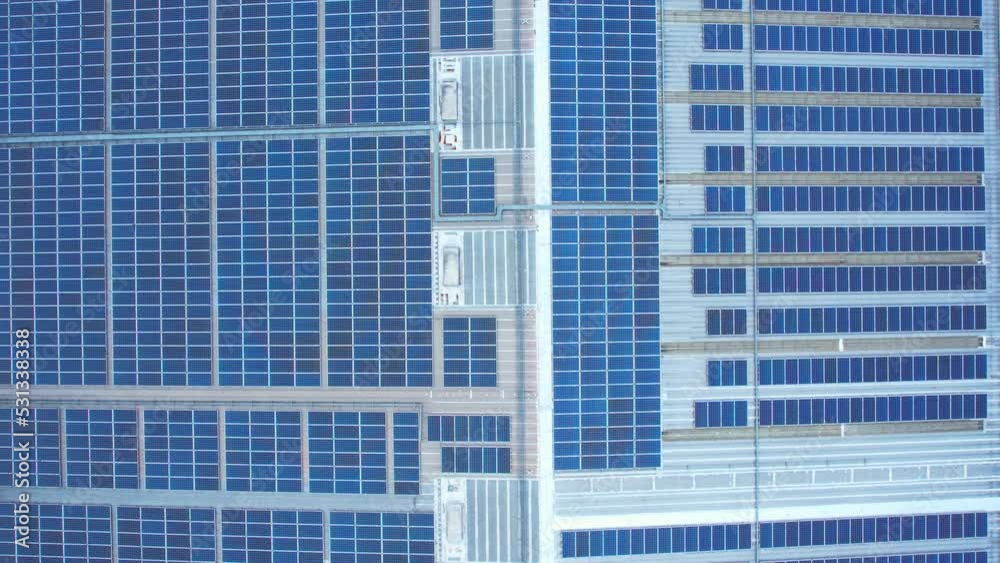 4K : Aerial view above blue solar photovoltaic modules on rooftop of factory during blue sky, alternative energy source. drone footage.
4K : Aerial view above blue solar photovoltaic modules on rooftop of factory during blue sky, alternative energy source. drone footage.