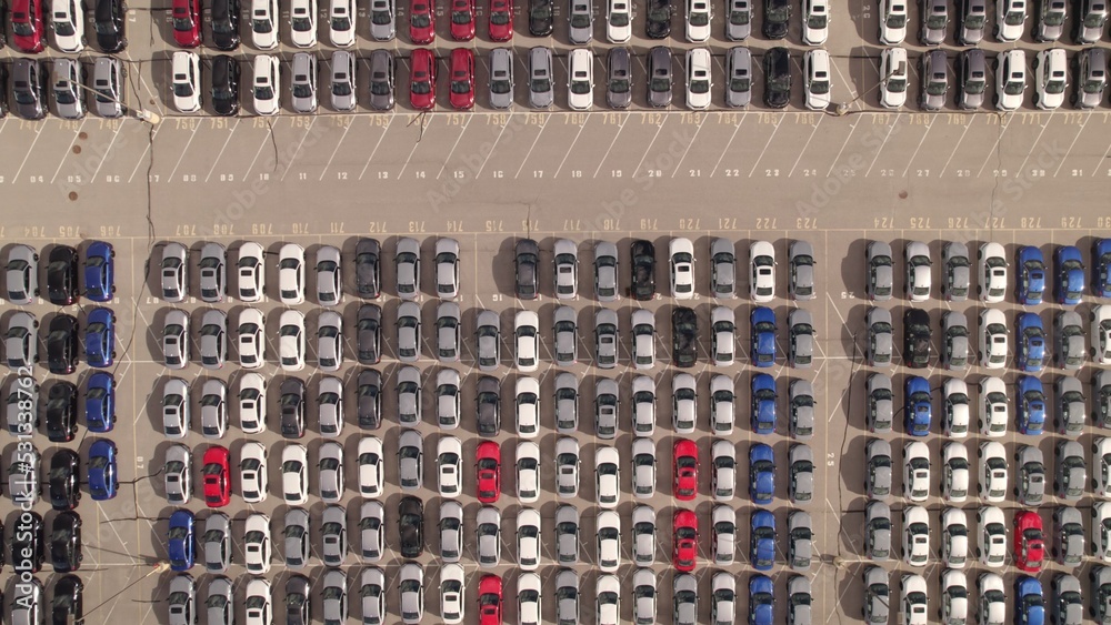 New cars located at the factory parking lot aerial view at golden hour. Car manufactory parking area for a new hybrid EV. High tech green electric vehicles sorted after industrial production conveyor. New cars located at the factory parking lot aerial view at golden hour. Car manufactory parking area for a new hybrid EV. High tech green electric vehicles sorted after industrial production conveyor.