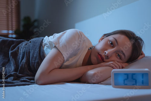 Asian women opened eyes lying on the bed have an insomnia problems.