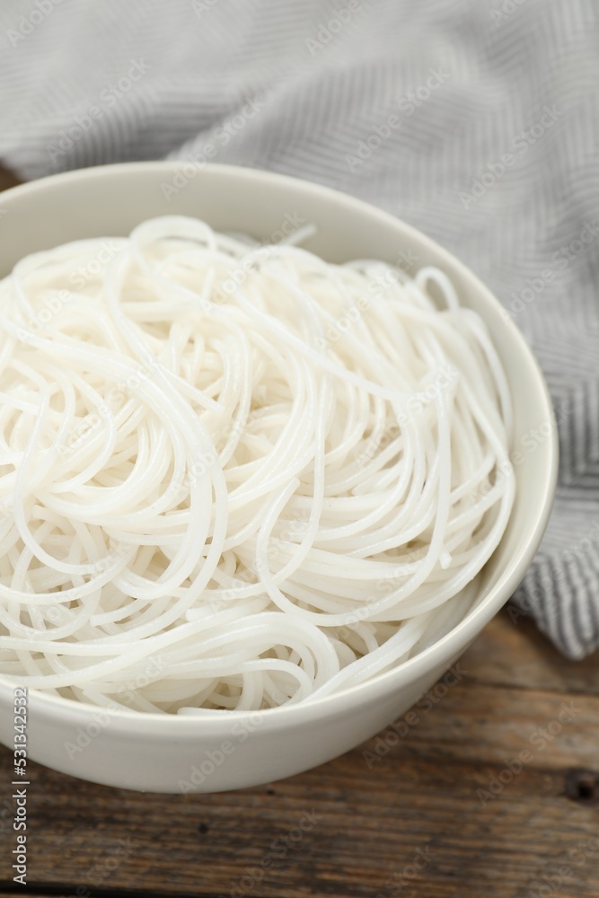 Bowl with cooked rice noodles on wooden table, closeup Bowl with cooked rice noodles on wooden table, closeup