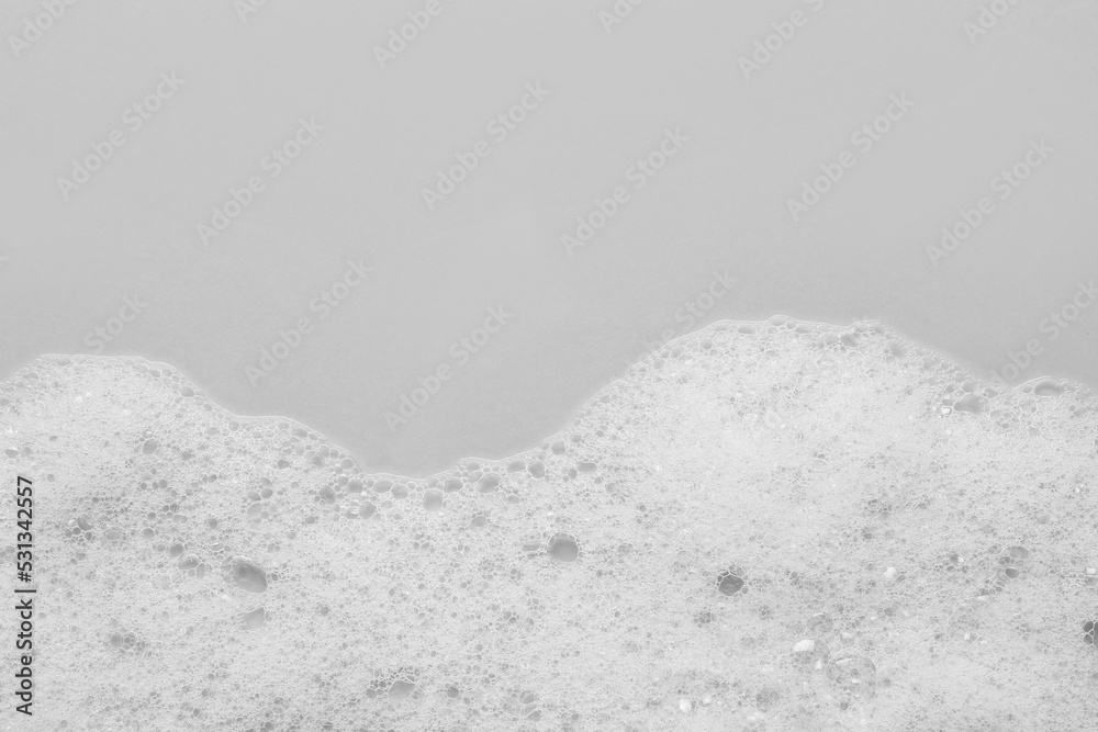 Fototapeta premium Fluffy bath foam on light background, top view. Space for text