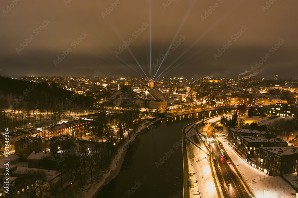 Scenic aerial view of Gediminas tower in Vilnius Old Town beautifully illuminated for 699 birthday celebration. Main symbol of Lithuanian capital at winter night.