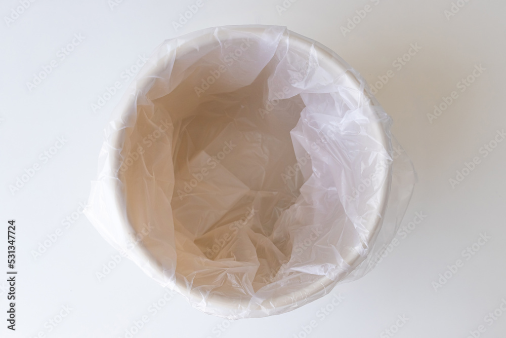 Empty trash container or bin with white plastic bag Empty trash container or bin with white plastic bag