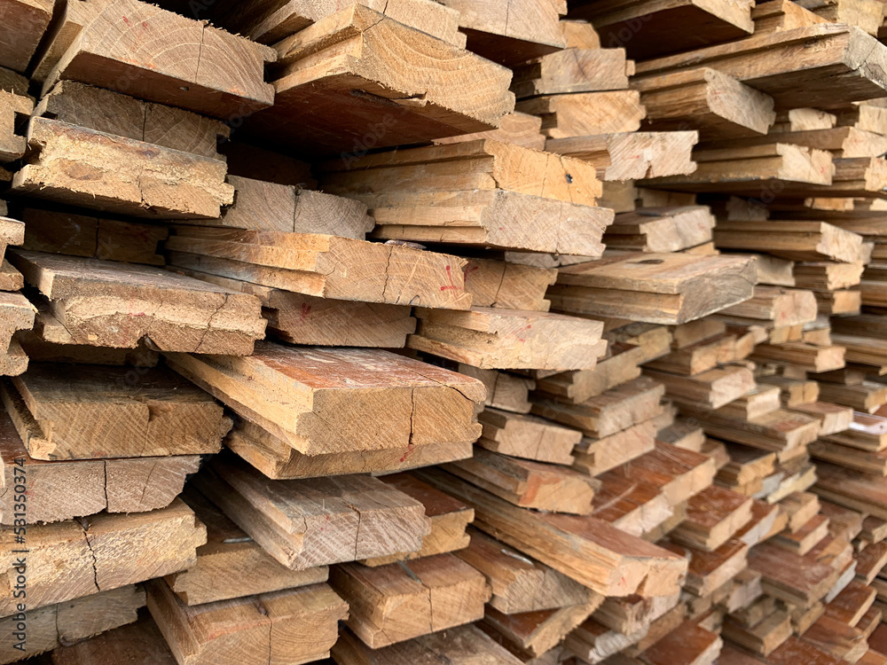 irregularly stacked timber abstract background, Old wooden boards preparing for the construction of the house, Pattern on the edge of several pieces of wood.mobile photo