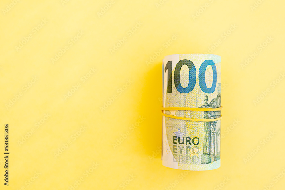 Money roll of euro banknotes with yellow rubber band on yellow background. cash paper currency, payment, earning and savings, european currency, money and finance concept. Empty space for text Money roll of euro banknotes with yellow rubber band on yellow background. cash paper currency, payment, earning and savings, european currency, money and finance concept. Empty space for text