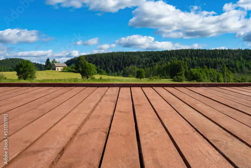Nature landscape. Wooden platform in picturesque place. Old wooden table in front of nature. Plank platform with blue summer sky. Place for displaying goods on wooden table. Board podium in nature