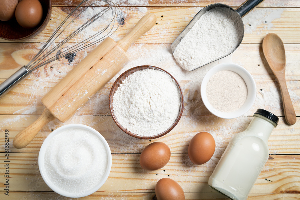 Homemade dough recipe (eggs, flour, milk, sugar) and kneaded dough on a wooden table. view from above Homemade dough recipe (eggs, flour, milk, sugar) and kneaded dough on a wooden table. view from above