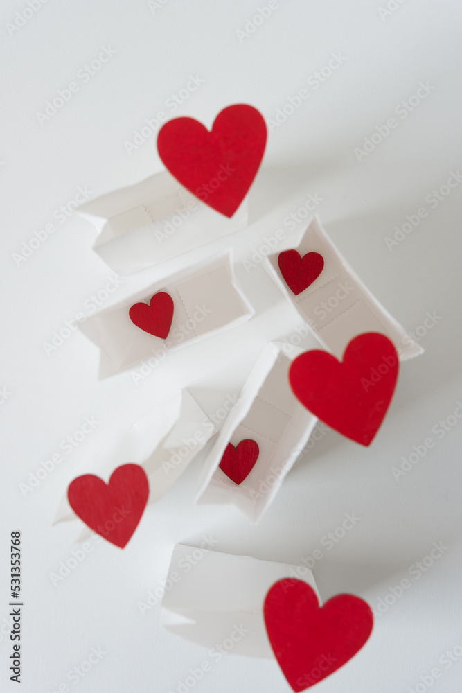 mini paper bags (open, top view) with grungy wooden hearts painted red 