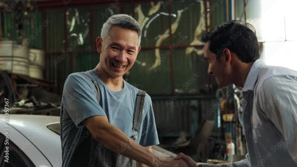 Handshake good deal and greeting. Asian young man customer talking with owner and mechanic worker at car repair service and auto store shop. Handshake good deal and greeting. Asian young man customer talking with owner and mechanic worker at car repair service and auto store shop.