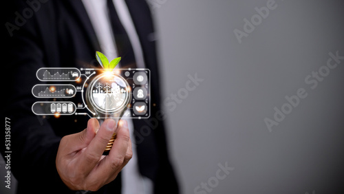 Businesswoman hand holding light bulb with esg icon on virtual screen, ESG Environmental, social and corporate governance concept