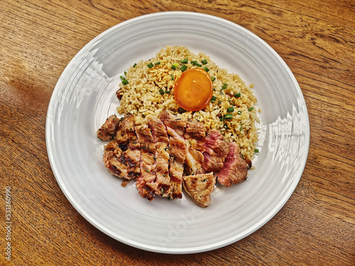 Fried Rice with Medium Rare Beef Steak and Egg on Wooden Table
