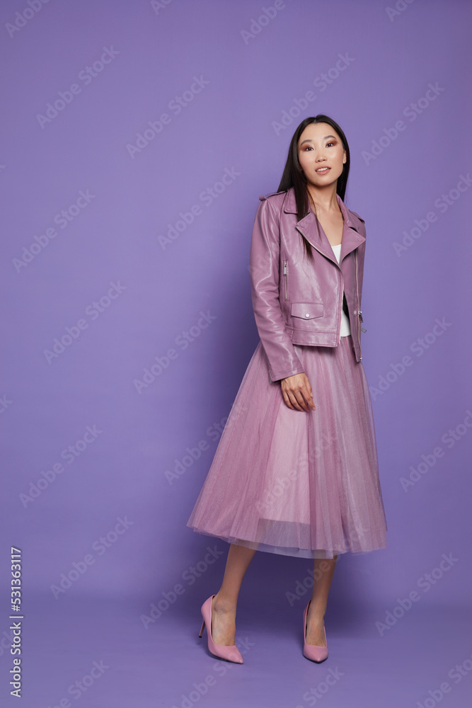 Fashion asian female model. Lilac leather jacket, lilac skirt, heels, sunglasses. Fashion asian female model. Lilac leather jacket, lilac skirt, heels, sunglasses.
