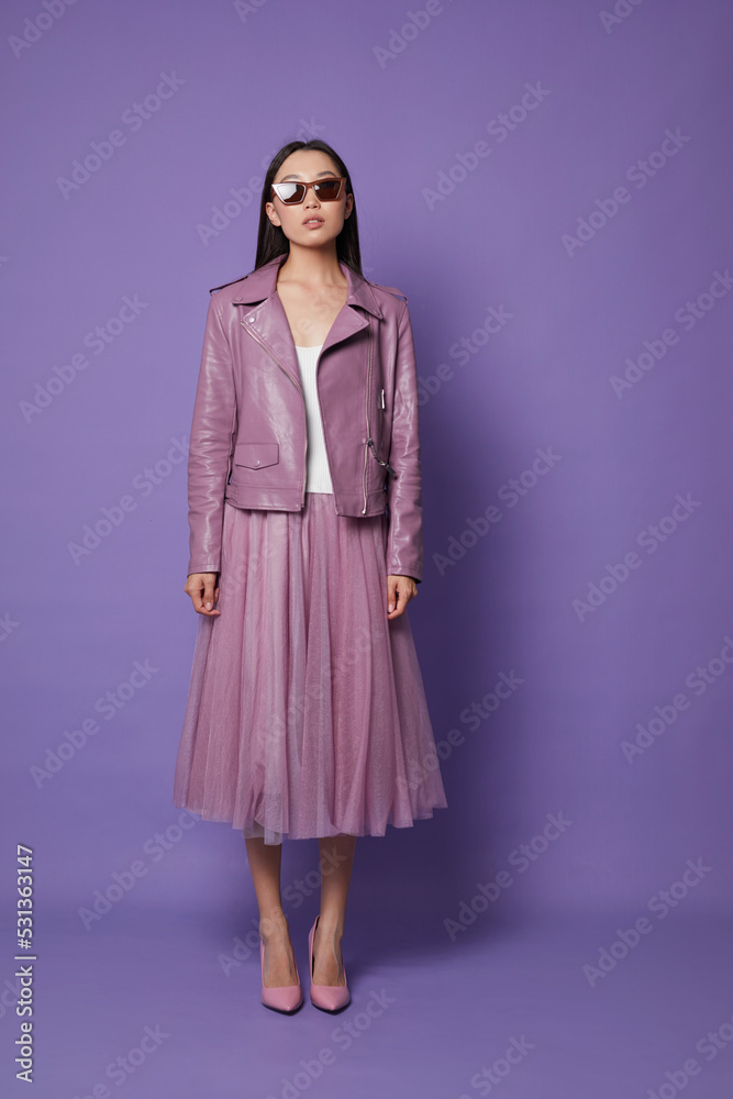 Fashion asian female model. Lilac leather jacket, lilac skirt, heels, sunglasses. Fashion asian female model. Lilac leather jacket, lilac skirt, heels, sunglasses.