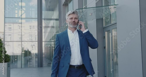 Business Man Using Mobile Phone Outdoors On Sunny Day At Street. Senior Person Talking Smartphone On Go During Break. Mature Guy Call To Colleague Near Office Building