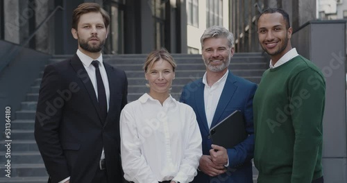 Portrait of Business People Standing at Street During Break. Four White Collar Workers in Formal Wear Near the Corporate Office, Urban Background