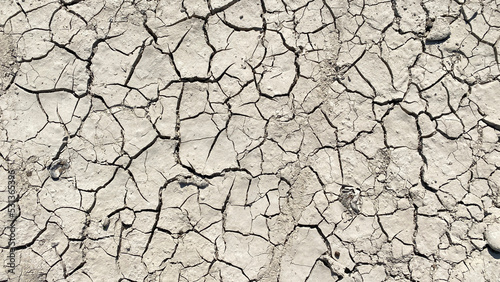 The dried up surface of the earth in the desert. Cracks on the surface of the earth.