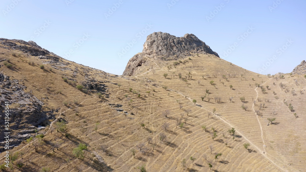 Aerial view of the desolate scorched surface of the sacred mountain of Osh Sulaiman-Too. View of the amazing mountains.