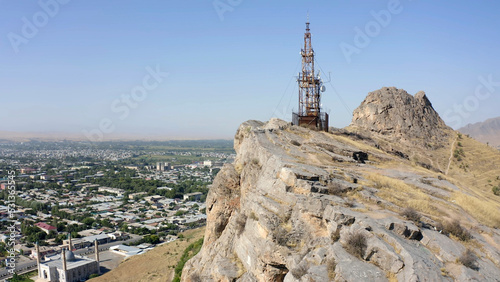 The cell tower stands on the rocky peak of the sacred mountain Sulaiman-Too. The city of Osh from a height. View of the amazing mountains.