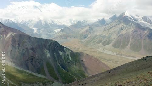 Aerial view of the enchanting multicolored mountains  snow-capped peaks and green hills of Kyrgyzstan. Beautiful mountain landscape.