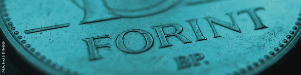 Hungarian coin of 10 forints lies on dark surface close up. Money of Hungary. News about economy or finance. Loan and credit. Magyar forint. Blue-green tinted business banner or header. Macro Hungarian coin of 10 forints lies on dark surface close up. Money of Hungary. News about economy or finance. Loan and credit. Magyar forint. Blue-green tinted business banner or header. Macro