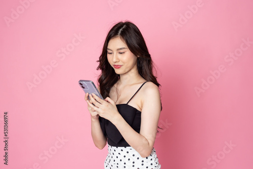 portrait asian young Women are happy while using smartphone isolated on pink background