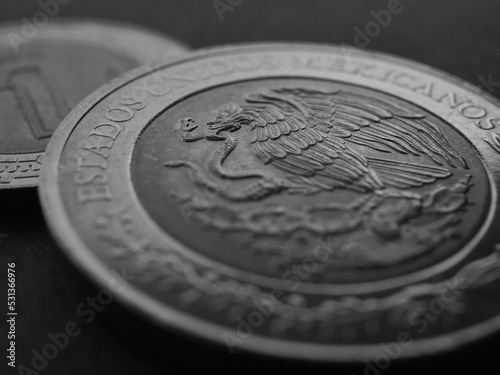 Coin of 5 five Mexican pesos closeup. Peso of Mexico. Reverse of coin with coat of arms of country. Eagle and snake. Black and white background. News about economy or banking. Credit and money. Macro