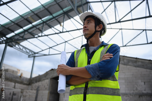 Portrait of Asian Civil Engineer People, Consulting in building structure at construction site holding the paper drawing in his hand. Management in business workflow and inspector in big projects