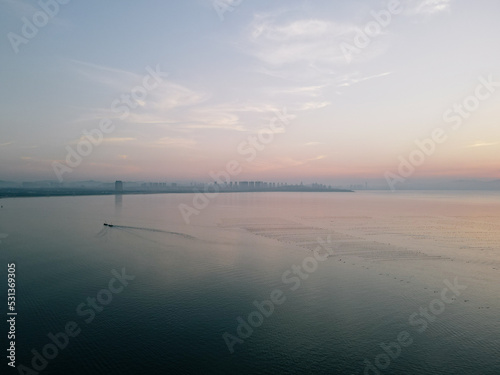 Aerial Drone Sunset View of the Pacific Ocean and the Skyline of Yantai City on Yangma Island  Shandong Province  China