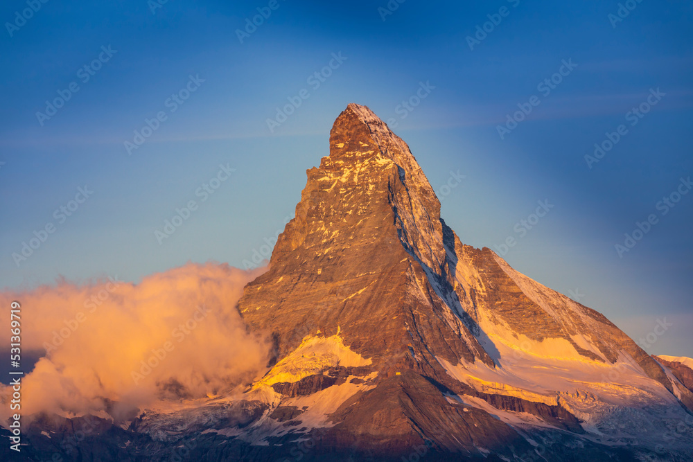 Beautiful landscape in the Swiss Alps in summer, with Matterhorn in the background, under warm sunrise light