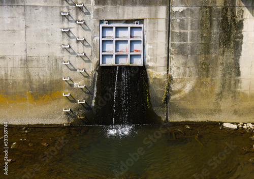 川に流れ込む鉄扉付き排水口 photo