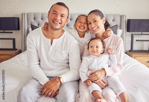Family happy, portrait smile and relax on bed together in home, parents love for children in the morning and happiness in bedroom. Mother and father relaxing with kids and caring on the weekend