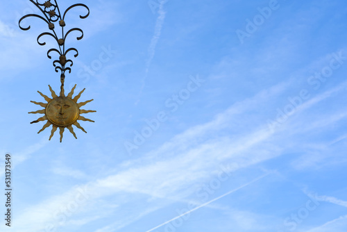 Sticker Blue sky with laughing sun of gold shining metal