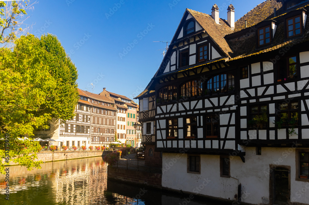 Picturesque view of old French town of Strasbourg with canals and ancient fachwerk houses at sunny summer day