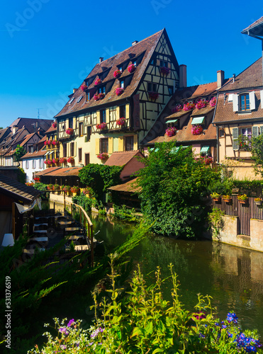 View of Little Venice, picturesque blooming old tourist area in historic center of Colmar city along canals of Lauch river on summer day, France
