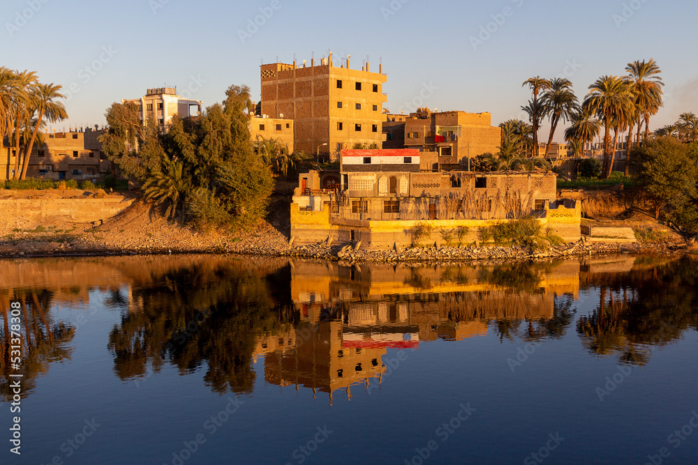 Cruise on the Nile River. Reflection of houses in the water. Egypt