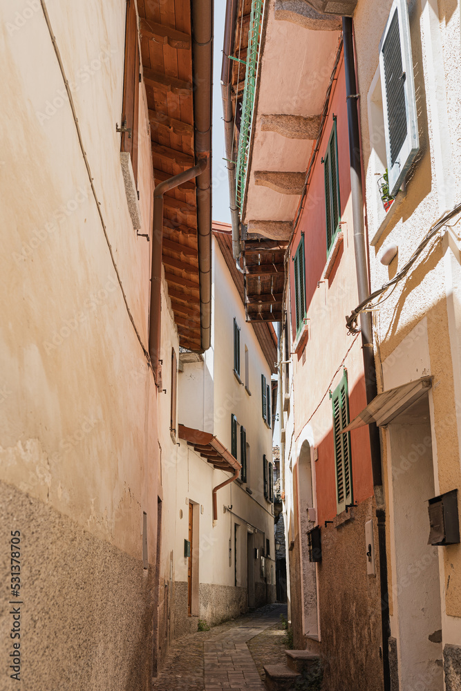 Old ancient Italian architecture. Traditional European old town buildings. Wooden windows, shutters and neutral color walls with sunlight shadows. Aesthetic summer vacation travel - obrazy, fototapety, plakaty 