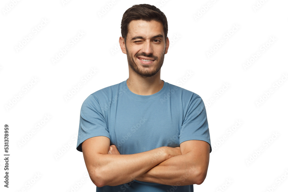 Handsome young man in blue t-shirt, with crossed arms smiling and winking, looking at camera Handsome young man in blue t-shirt, with crossed arms smiling and winking, looking at camera