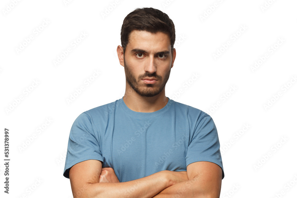 Young man in blue t-shirts tanding with arms crossed and serious concentrated face at camera, looking aggressive Young man in blue t-shirts tanding with arms crossed and serious concentrated face at camera, looking aggressive