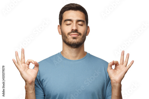 Yoga and meditation concept. Concentrated relaxed man standing with closed eyes, having relaxation while meditating