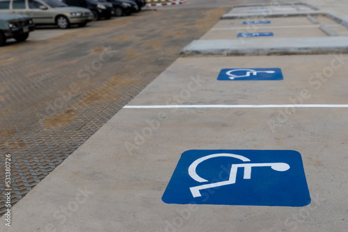 Group of empty disable person parking sign or wheelchair symbol in the parks with no people and blurred outdoors background. Selective focus and copy space.