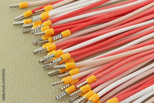 Copper electrical wires in colored insulation on a colored background close-up.