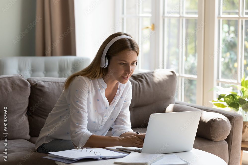 Happy engaged student woman in wireless headset studying from home. attending online class, talking on video call on laptop. Teacher, blogger giving webinar, workshop Happy engaged student woman in wireless headset studying from home. attending online class, talking on video call on laptop. Teacher, blogger giving webinar, workshop