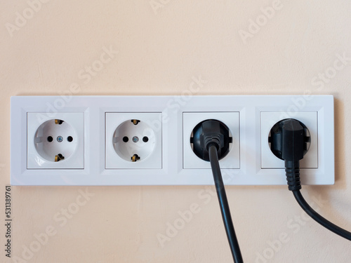 Two electrical power plugs for household appliances are connected to the electrical network. Unplug half of the electrical appliances from the outlet.