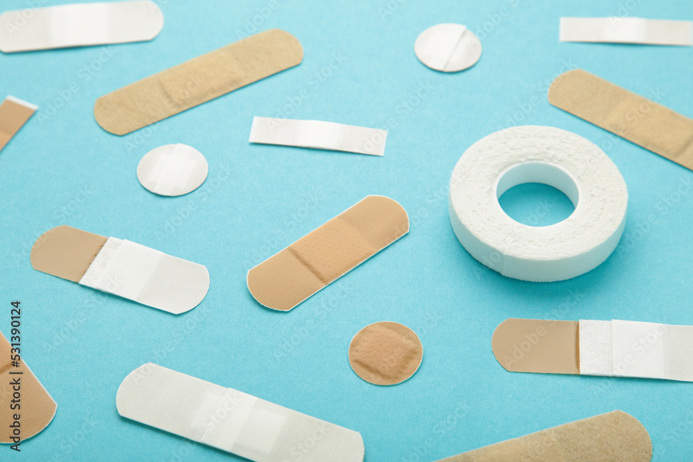 Beige adhesive bandages on blue background. Medical plasters