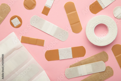 Billede på lærred Beige adhesive bandages on pink background. Medical plasters