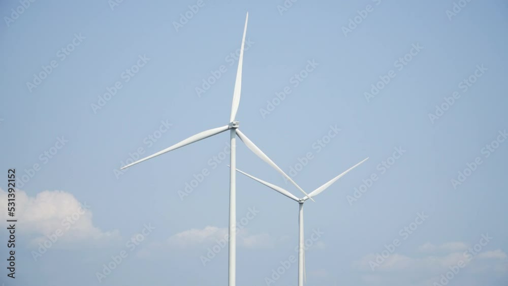 Two wind turbines turning over blue sky Two wind turbines turning over blue sky