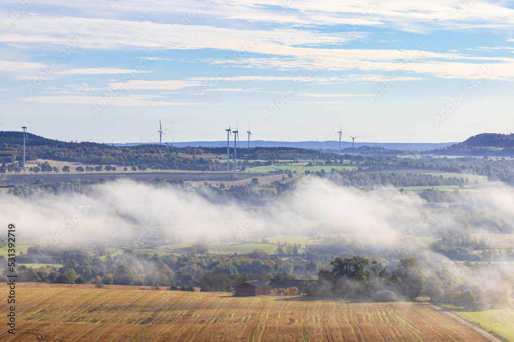 Landscape view with mist and wind turbines