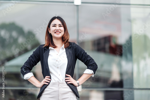 Portrait of young Asian business woman smiling akimbo outdoor of terminal in airport