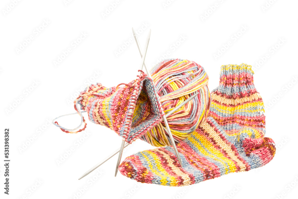 Isolated handmade woolen socks with knitting equipment