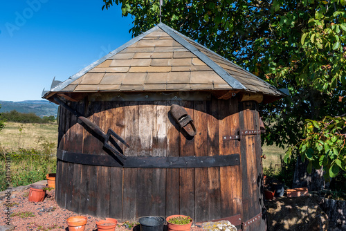 petite maison de bois en forme de tonneau avec un sabot et une fourchette de suspendue au mur sur le chemin de randonnée des chaux à Saint Gervazy dans le puy de dôme photo